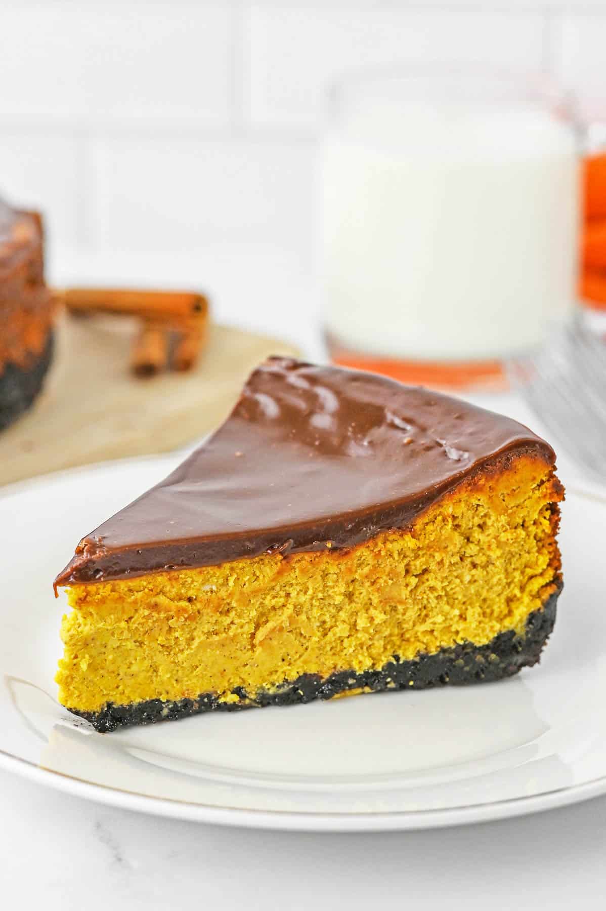 A single slice of chocolate pumpkin cheesecake on a small white plate.