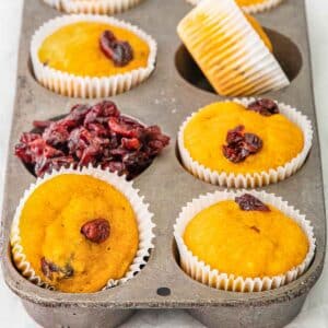 Delicious cranberry pumpkin muffins in a muffin tin.