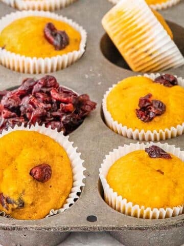 Delicious cranberry pumpkin muffins in a muffin tin.