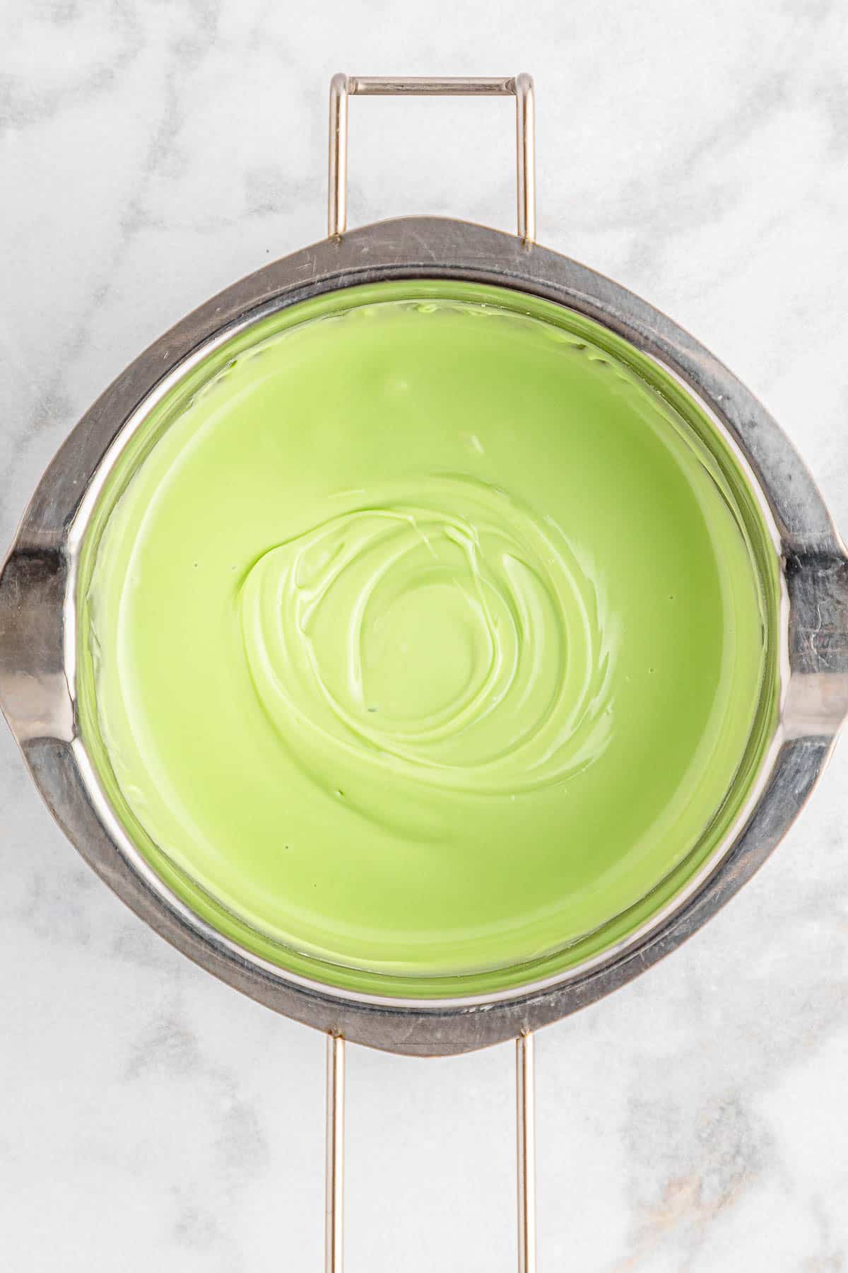 A bowl of melted green candy melt.