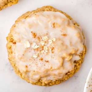 Iced oatmeal cookies with cinnamon and icing on a white plate.