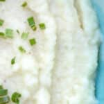 Garlic mashed cauliflower served on a blue plate.