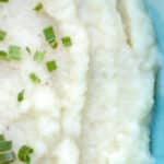 Garlic mashed cauliflower served on a blue plate.