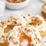 Delicious maple donuts recipe with creamy maple frosting topped with chopped nuts.