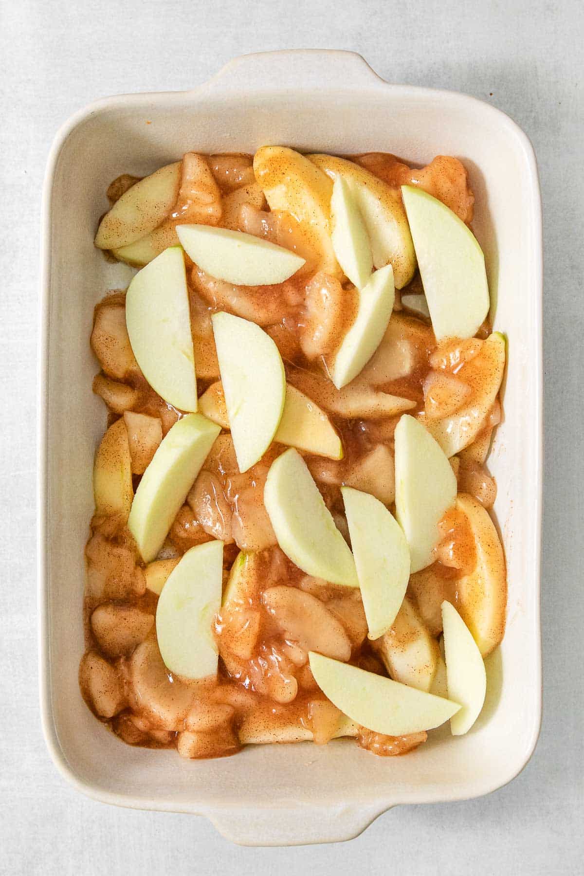 Sliced apples in a rectangle baking dish.