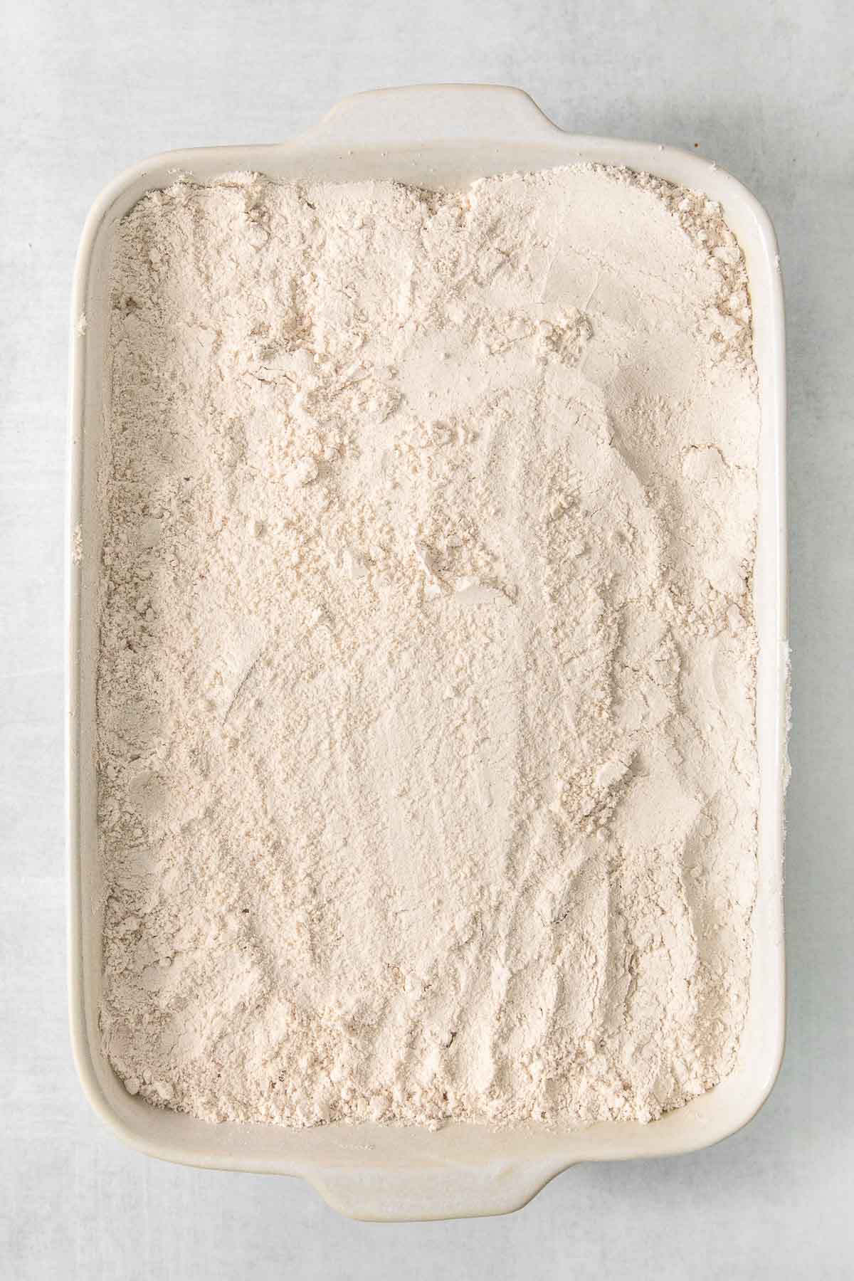 A white baking dish filled with dry cake mix.