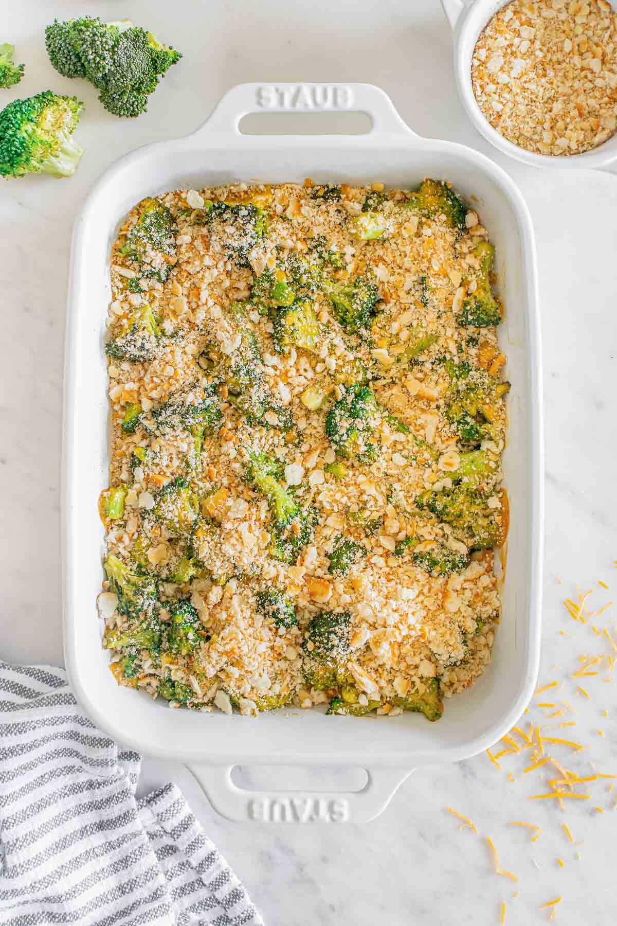 A casserole dish with broccoli casserole with a buttery cracker topped baked in it.