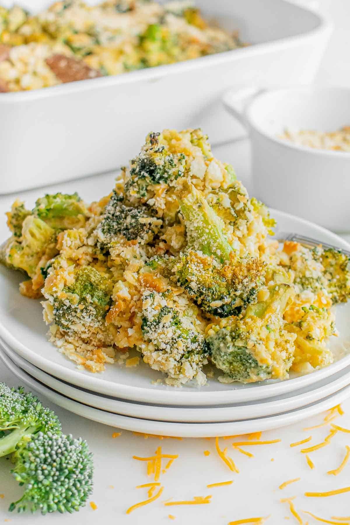 A white plate with cheesy broccoli casserole on it.