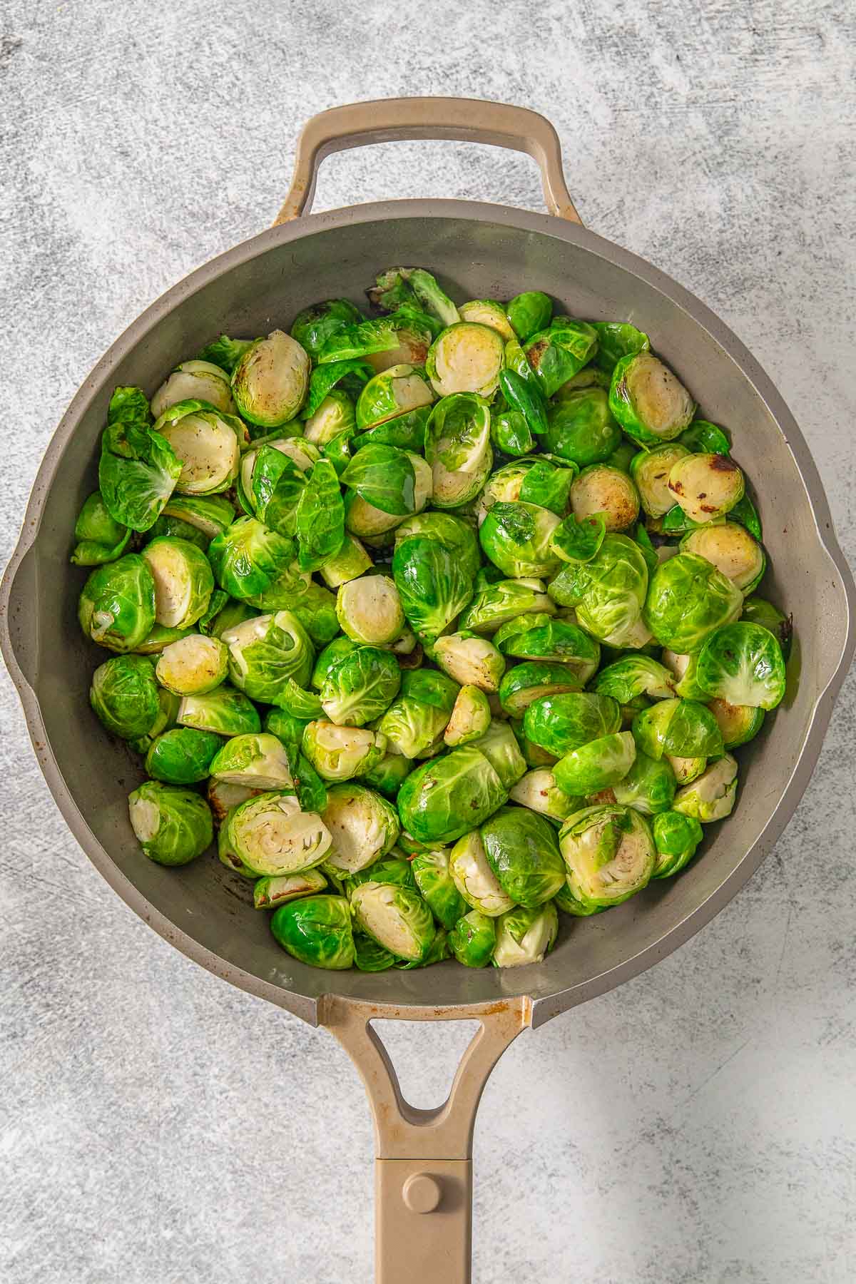 Brussel sprouts cooking in a skillet.