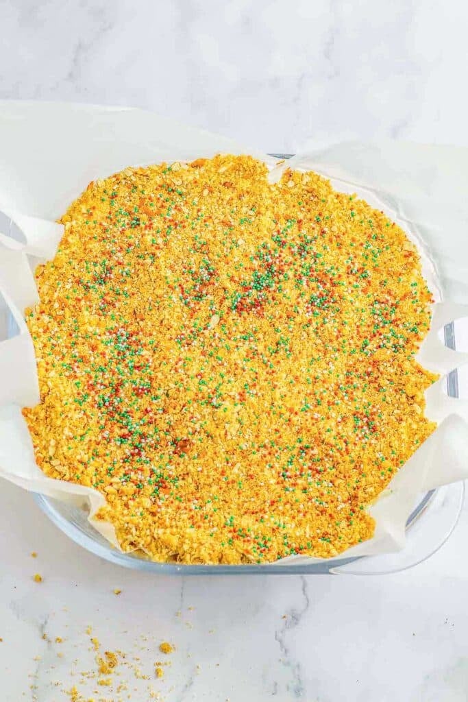Crumb mixture on top of cake sprinkled with christmas sprinkles.