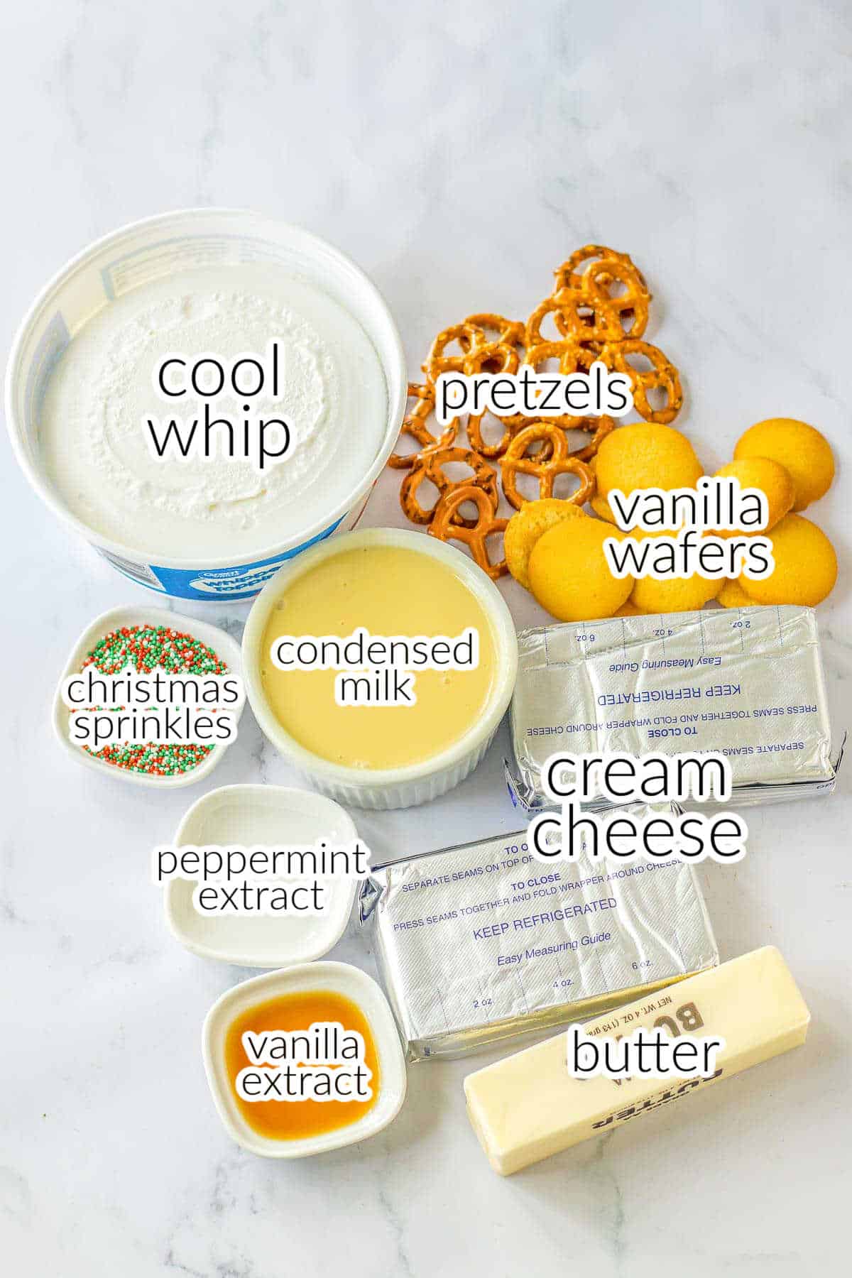 ingredients for Christmas crunch cake - cool whip, pretzels, vanilla wafers, condensed milk, christmas sprinkles, cream cheese, peppermint extract, vanilla extract and butter.
