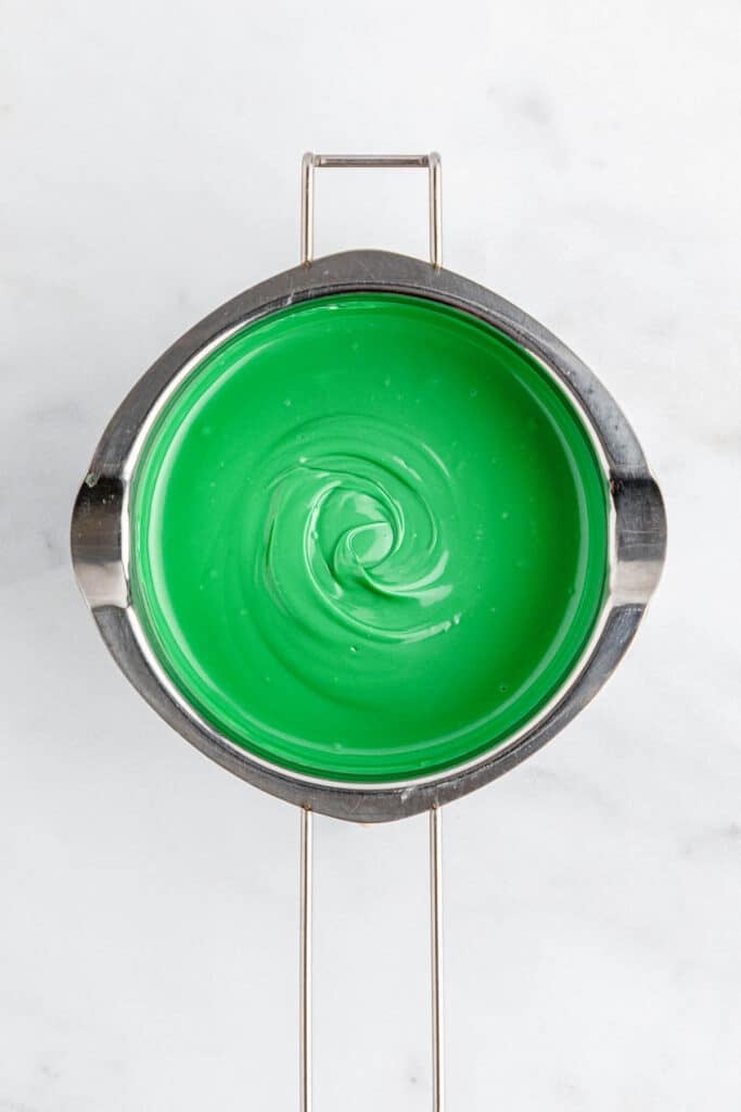 A silver pot of green melted candy wafers.