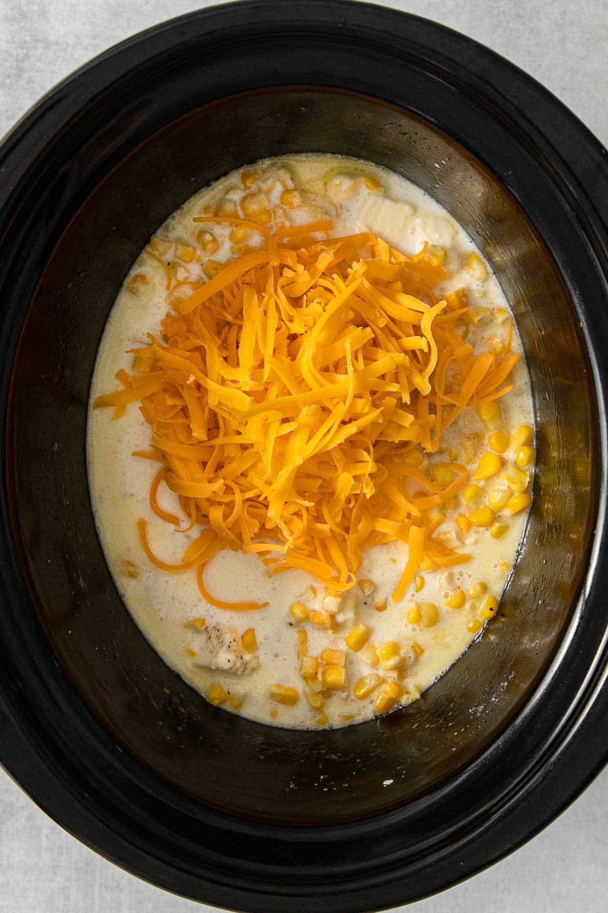 Cheddar cheese added to crockpot mixture.