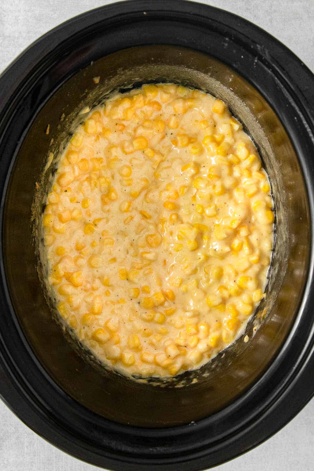 A crock pot filled with crockpot creamed corn.