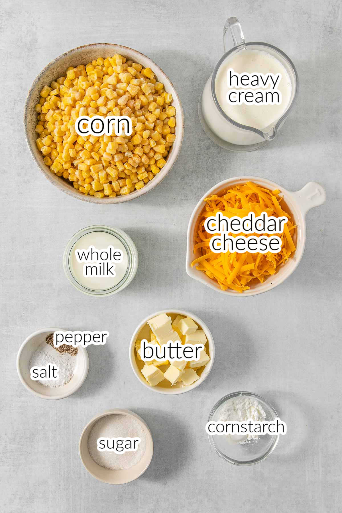 A list of ingredients for crockpot creamed corn - corn, heavy cream, whole milk, cheddar cheese, butter, cornstarch, salt, pepper and sugar.