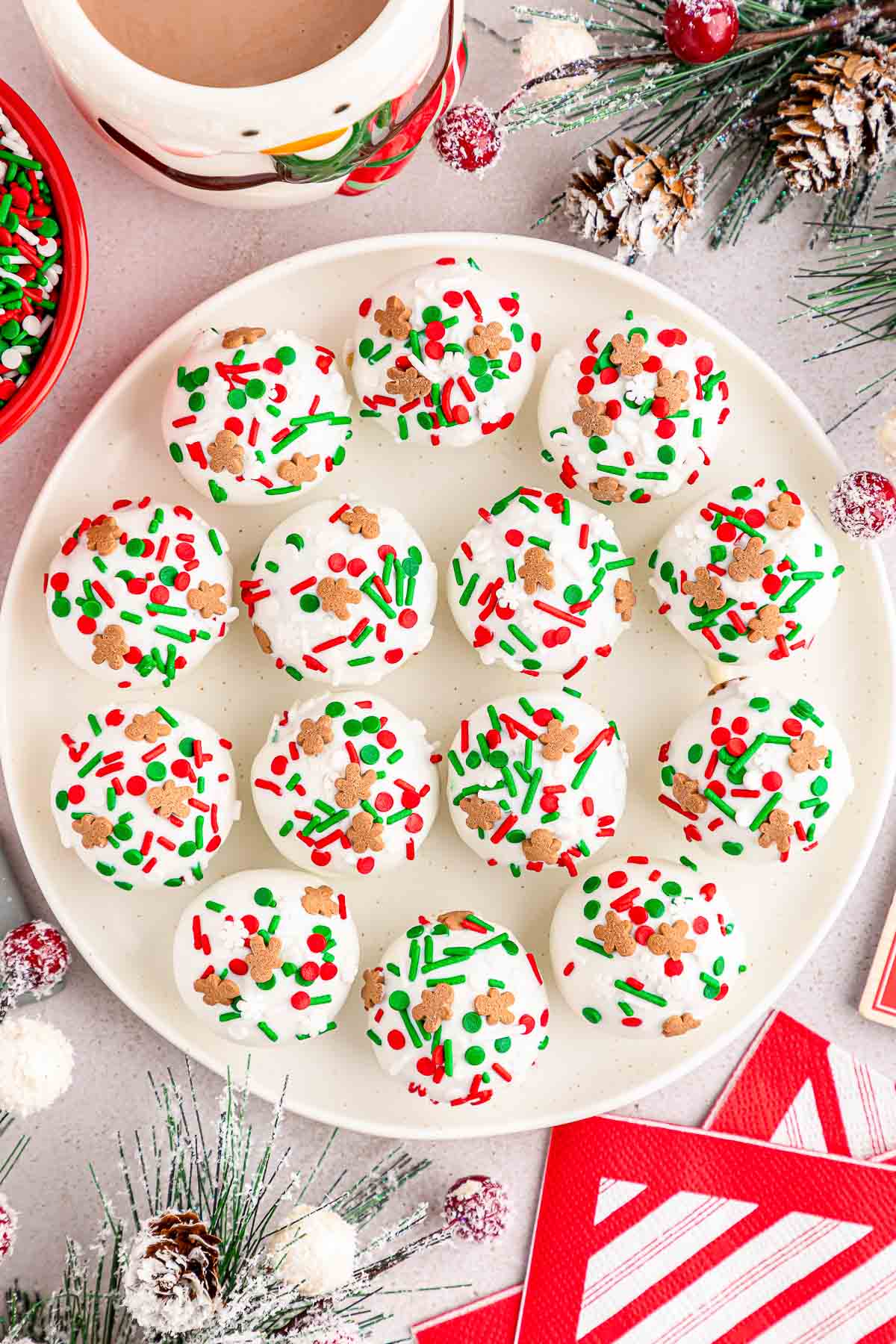 Several gingerbread truffles with sprinkles on a white plate.