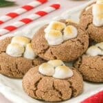 Multiple hot chocolate cookies with marshmallows on a plate.