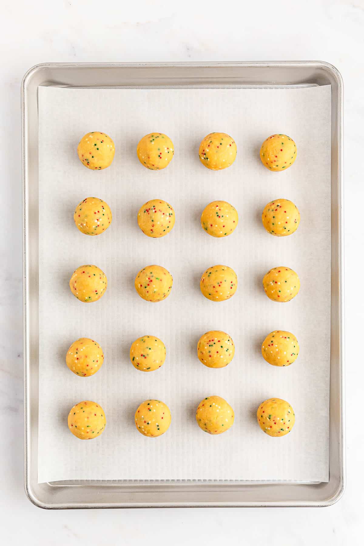 A baking sheet with golden oreo balls.