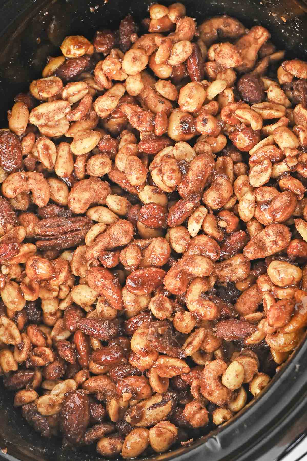 A slow cooker filled with candied nuts.