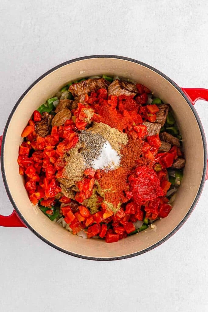 A red pot filled with vegetables and spices.