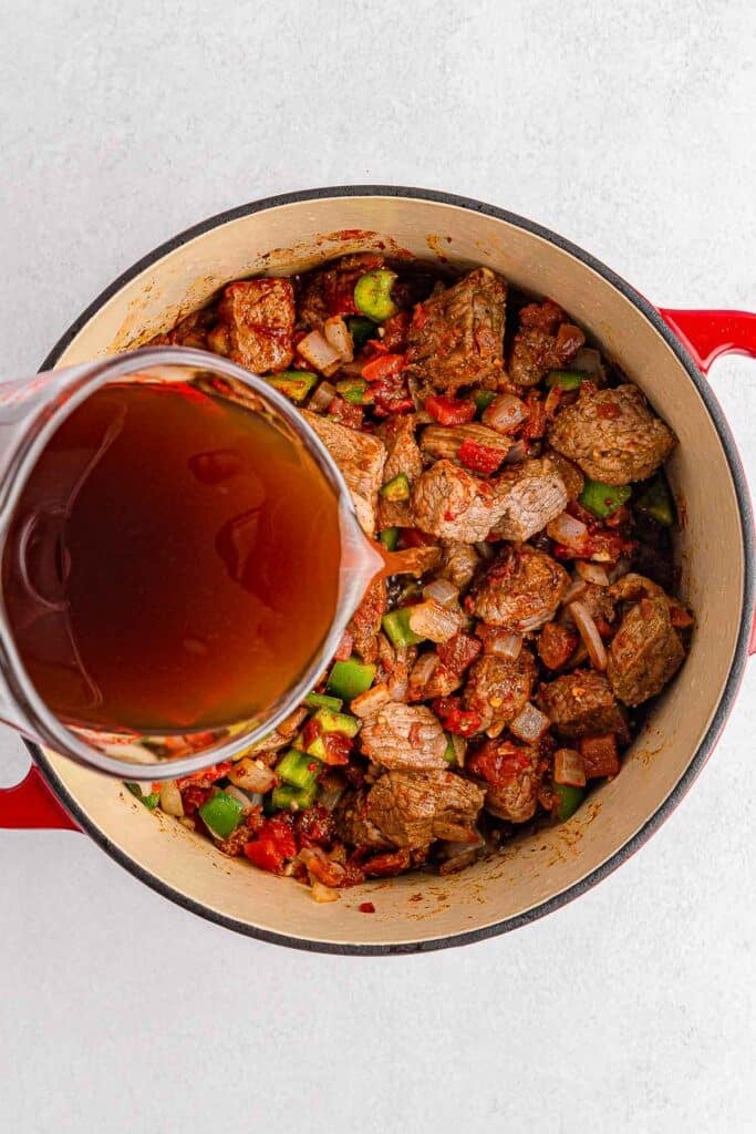 A pot with meat and sauce on a white background.