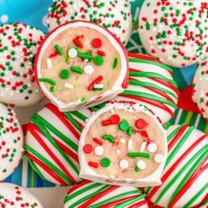 Several sugar cookie truffles stacked on a holiday plate.