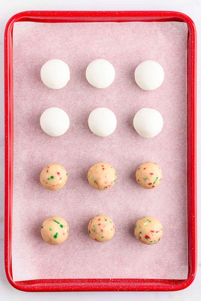 A baking sheet of Sugar cookie dough with half coated in white candy melt.