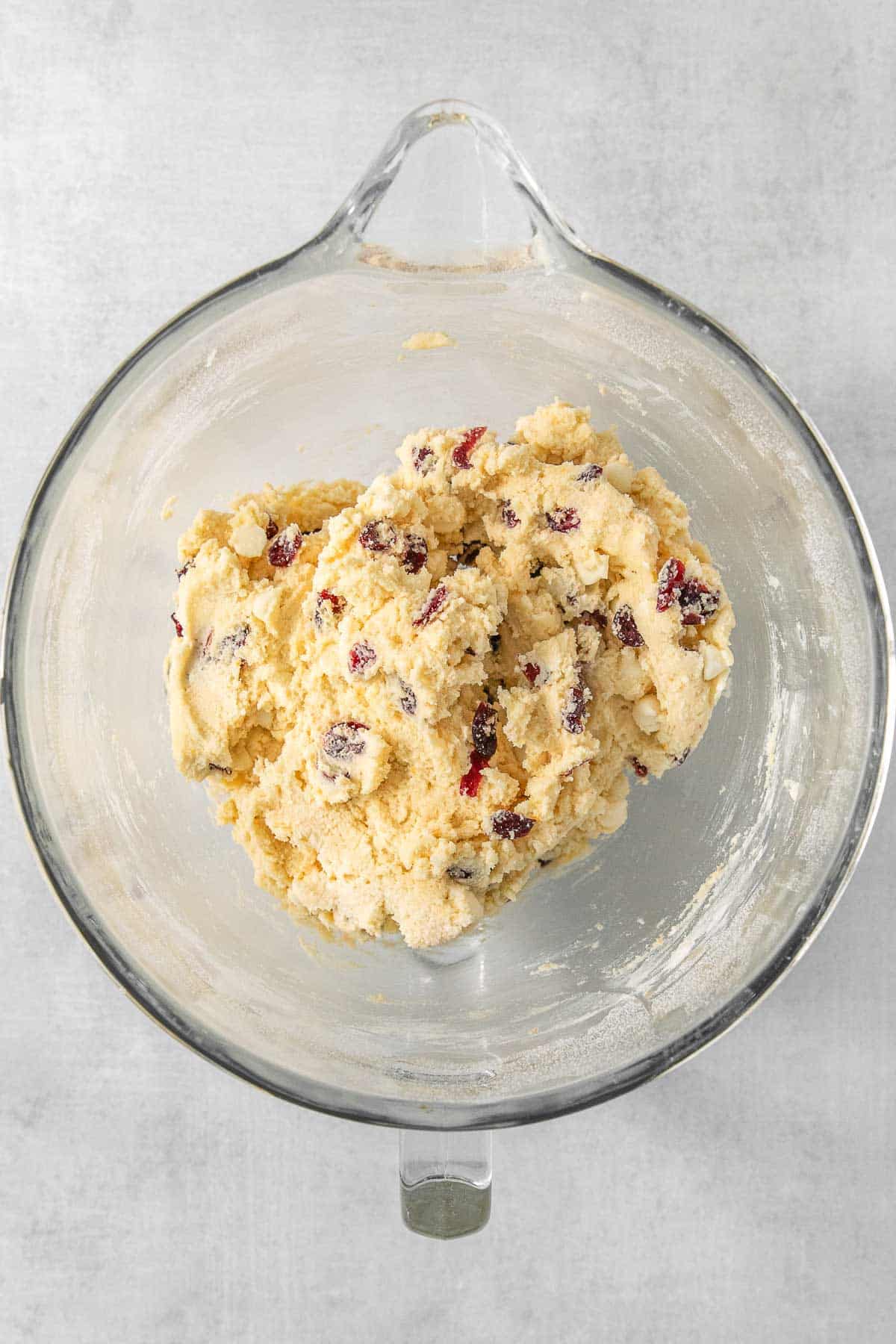 White chocolate cranberry cookie dough in a glass mixing bowl.