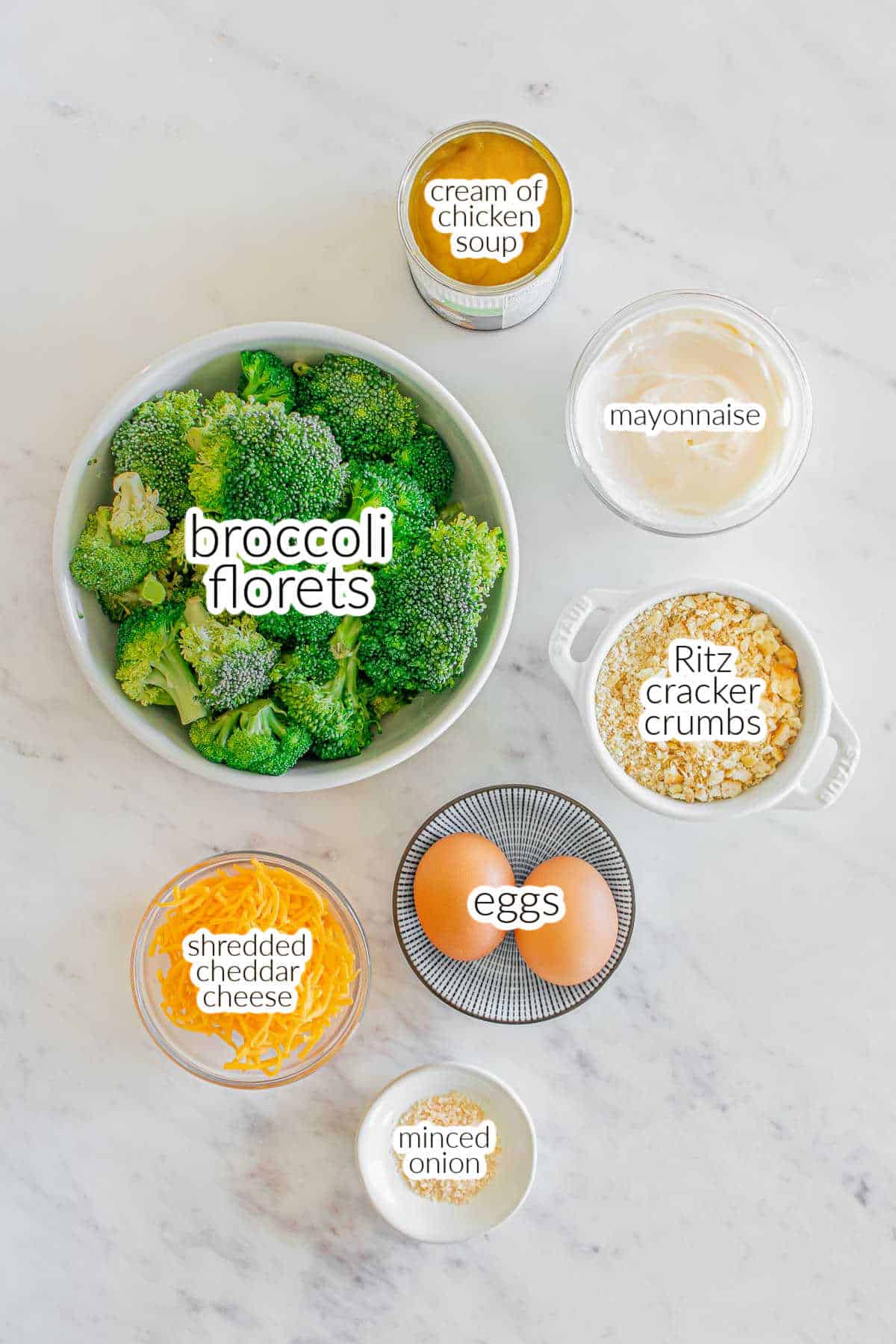 Ingredients for a broccoli casserole - fresh broccoli, cream of chicken soup, mayonnaise, Ritz cracker crumbs, shredded cheddar, eggs, minced onion.