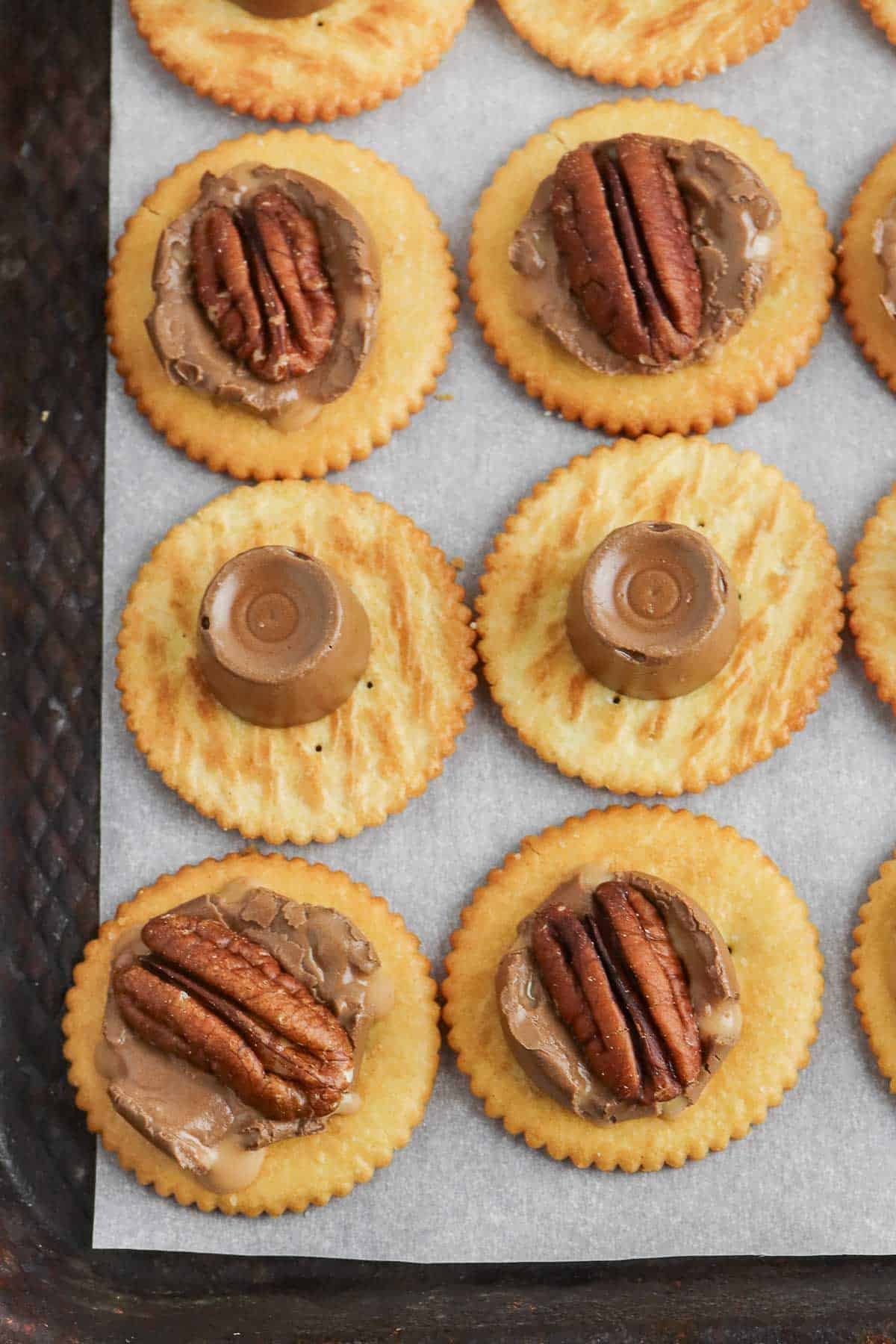 ritz crackers topped with a Rolo candy and pecan half on some.