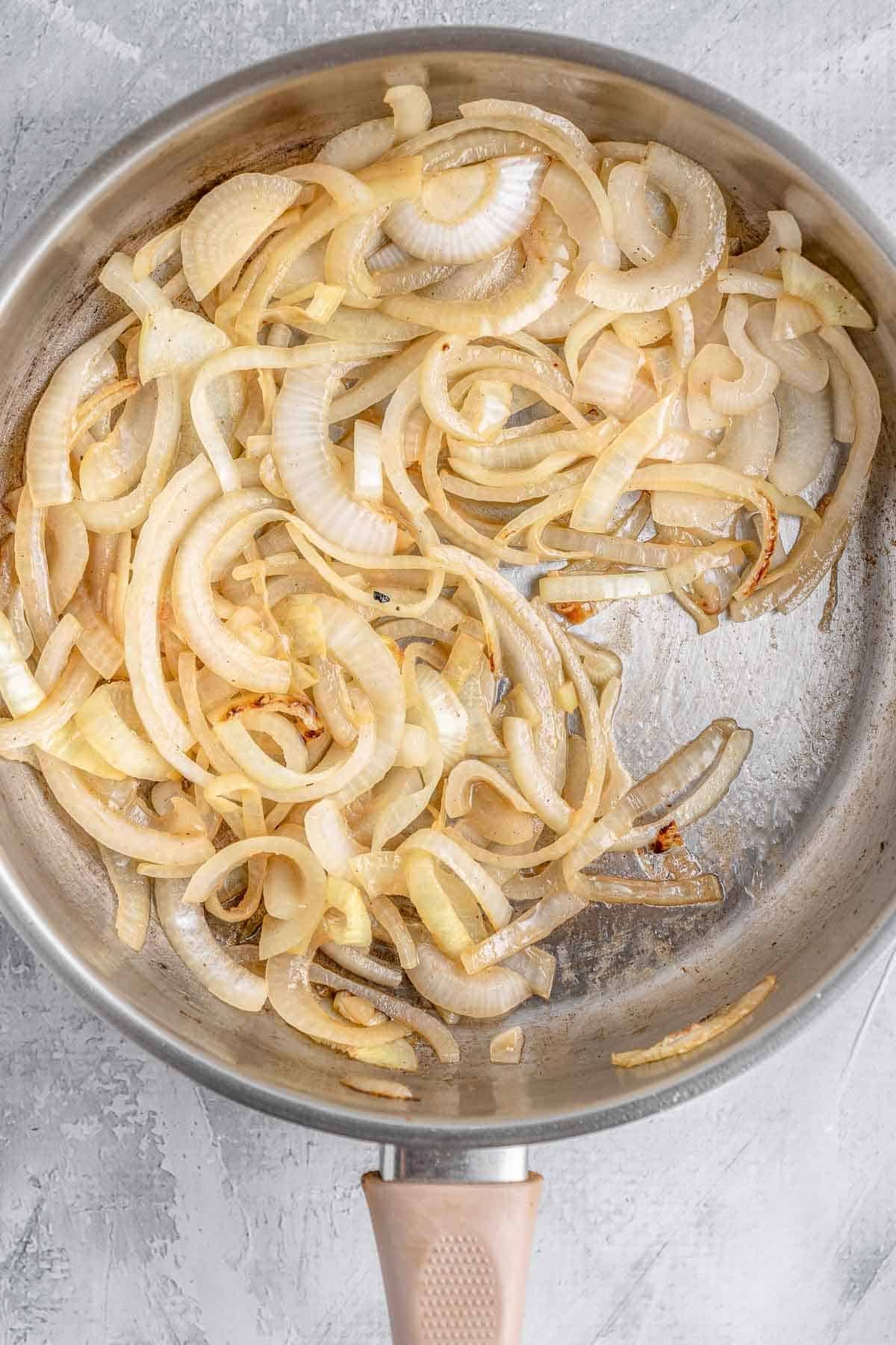 Sliced onions sautéing in a skillet