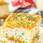 Festive Christmas cheesecake bars adorned with a delightful sprinkle of holiday joy on a plate.