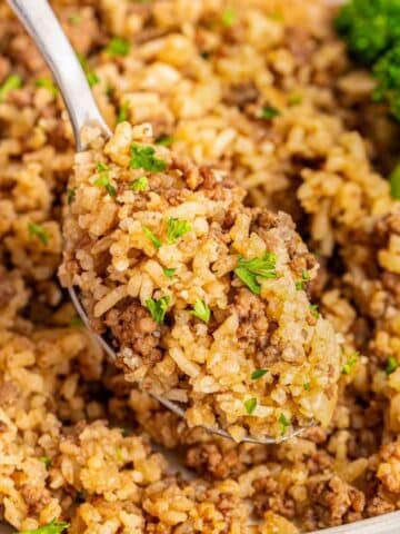 A spoonful of hamburger rice casserole with meat and broccoli.