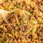 A wooden spoonful of hamburger rice casserole.