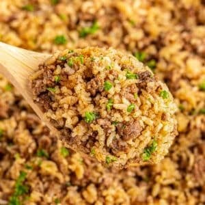 A wooden spoonful of hamburger rice casserole.