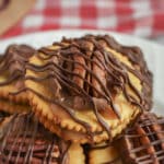 Ritz cracker cookies with chocolate and pecans on a plate.