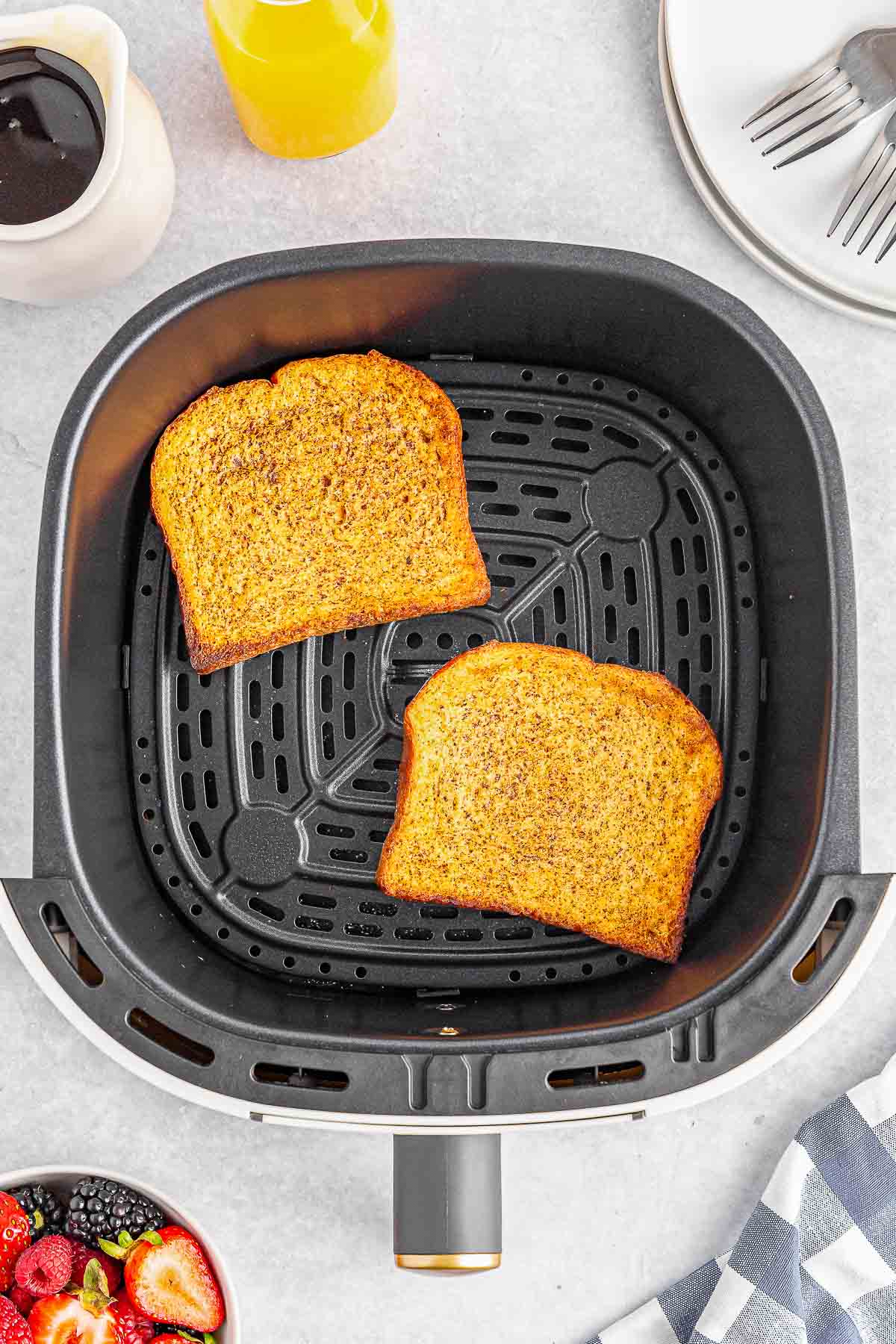 Two slices of coated french toast bread cooked in an air fryer.
