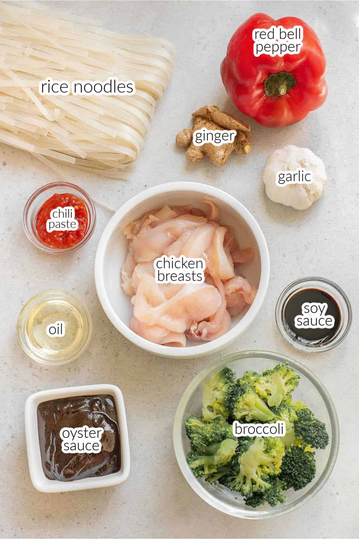Ingredients for thai drunken noodles recipe - ice noodles, raw chicken strips, broccoli, red bell pepper, chili paste, garlic, ginger, oyster sauce.