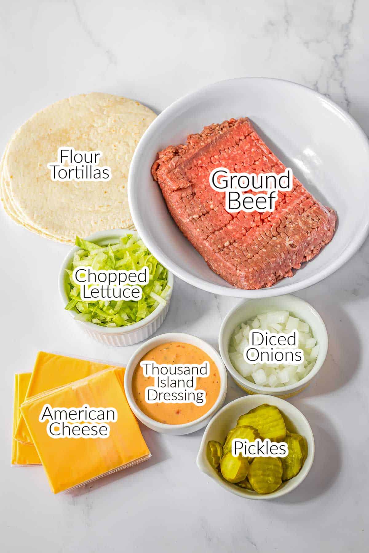 The ingredients for Smash Burger Tacos - ground beef, flour tortillas, diced onions, pickles, thousand island dressing, chopped lettuce and american cheese.