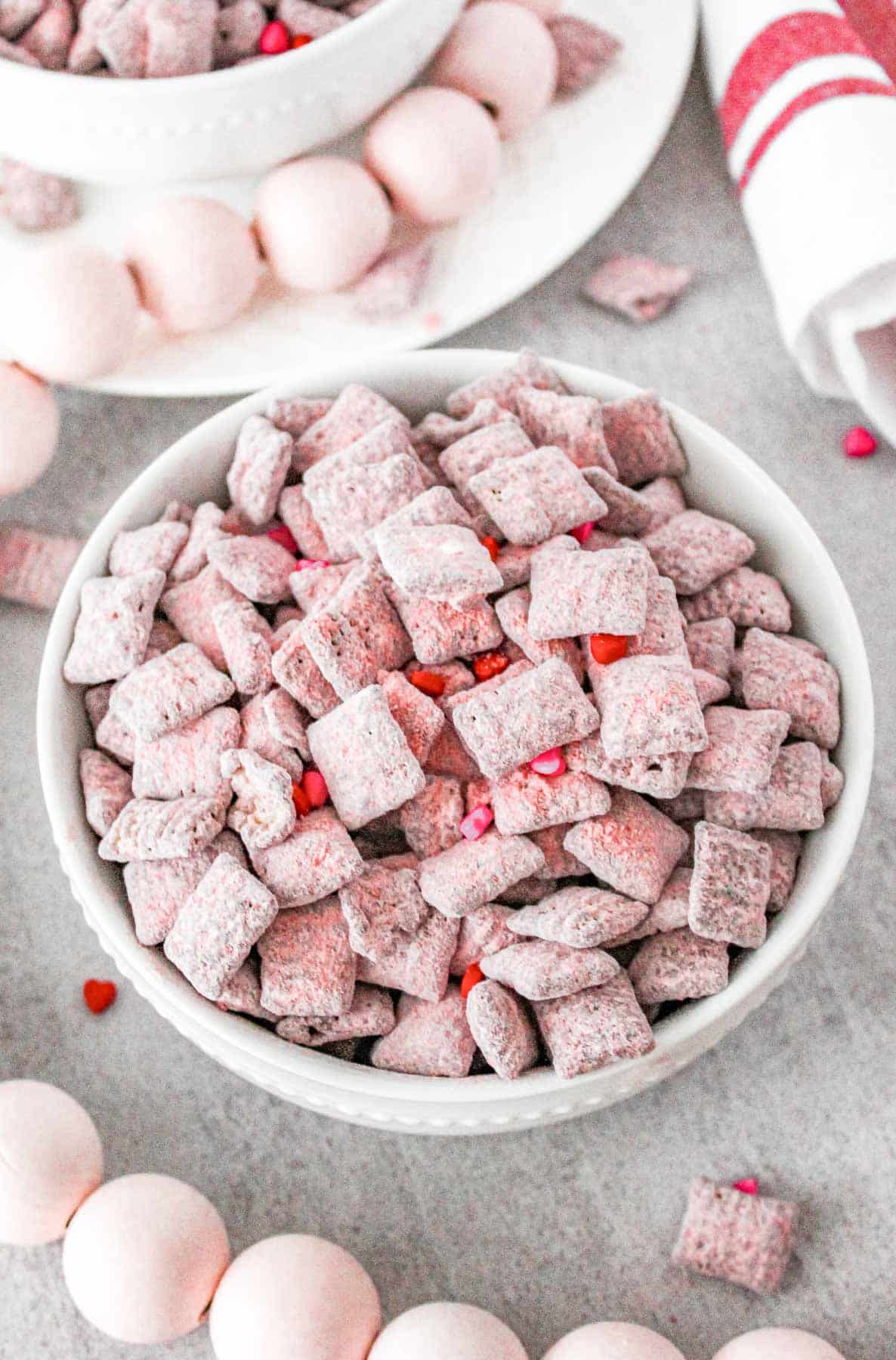 A bowl of pink strawberry cheesy muddy buddies for Valentine's Day.