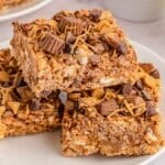 A stack of peanut butter rice krispie treats on a white plate.