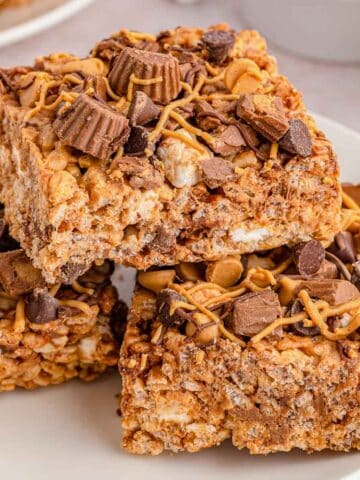 A stack of peanut butter rice krispie treats on a white plate.