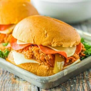 Two pizza sloppy joe sliders on a metal tray.