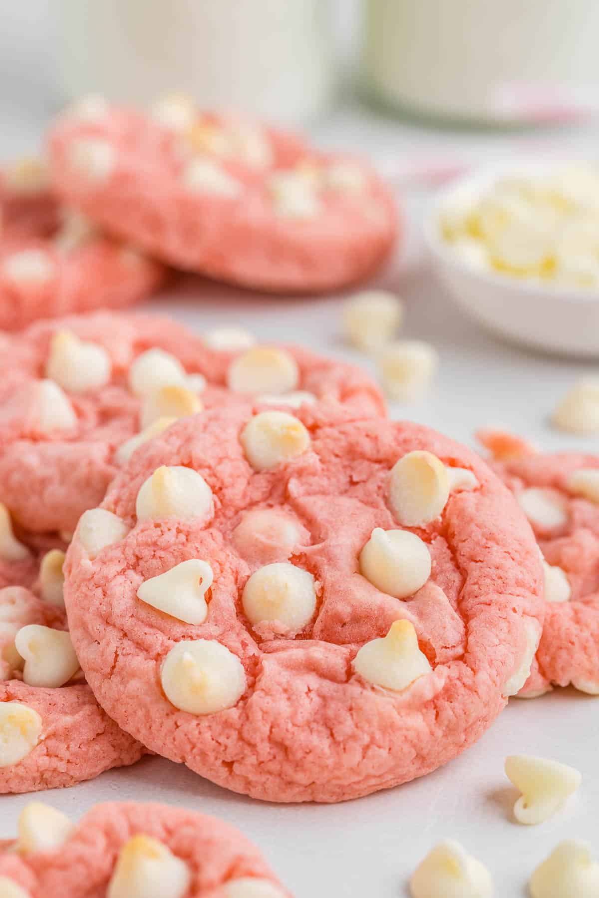 A pile of strawberry cookies with white chocolate chips.