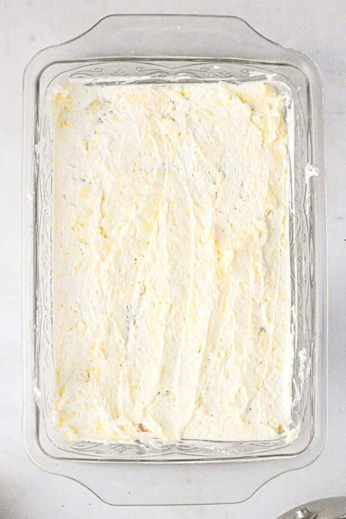 A baking dish coated on the bottom with a creamy filling spread evenly.