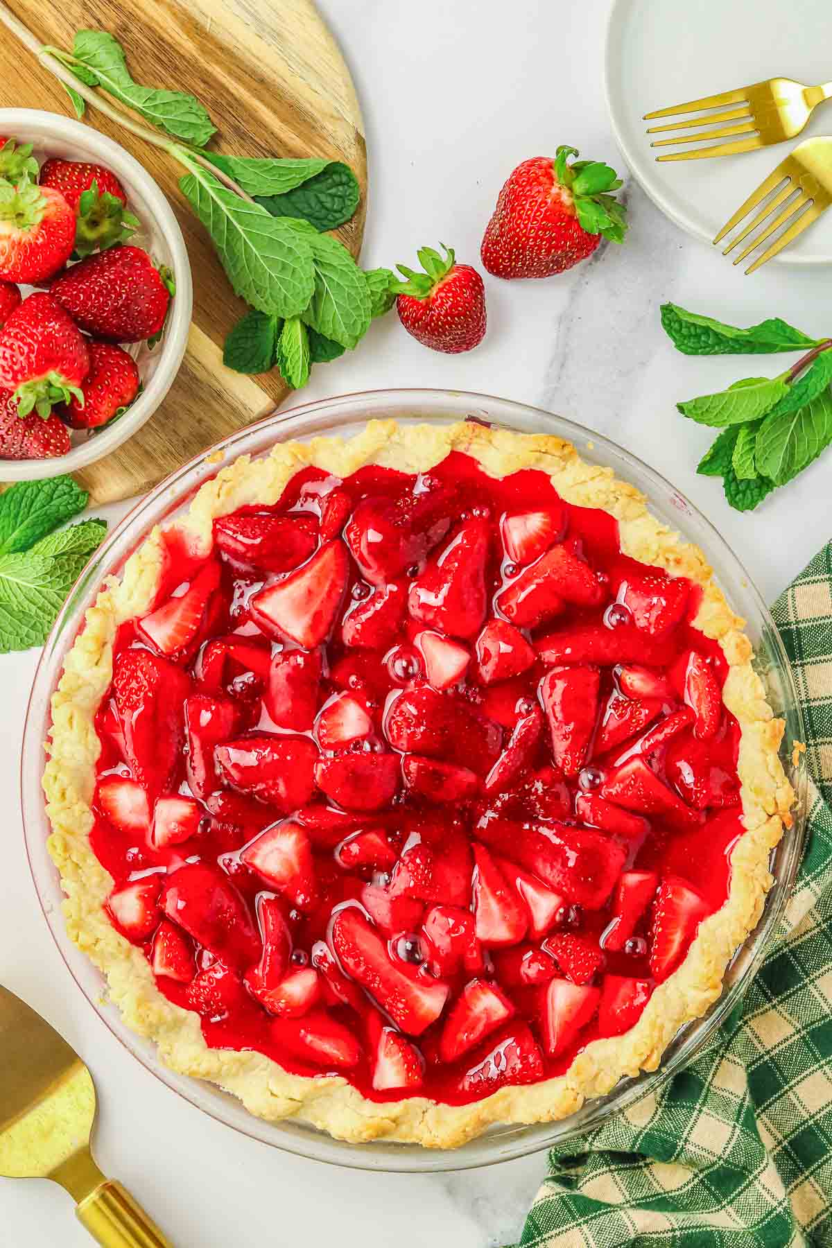 A strawberry pie in a large glass pie plate.