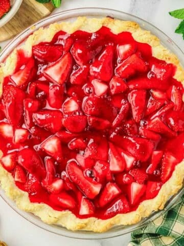 A strawberry pie in a large glass pie plate.