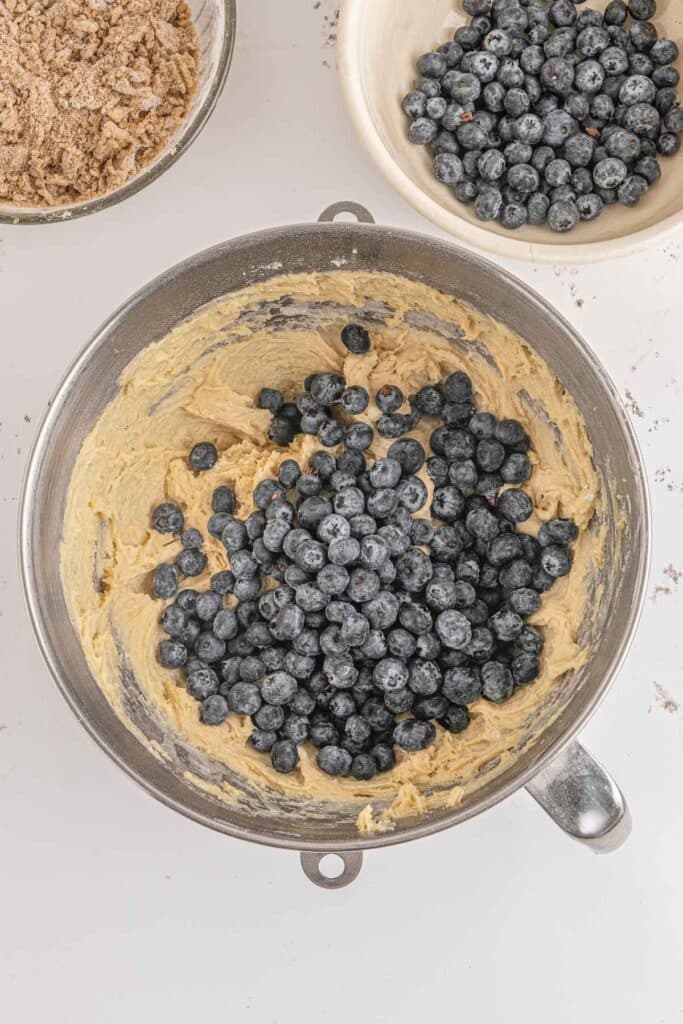 A bowl of blueberry buckle batter with fresh blueberries mixed in.