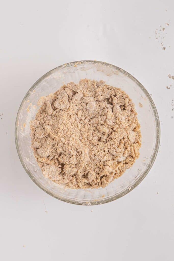 Streusel topping mixture in a glass mixing bowl.