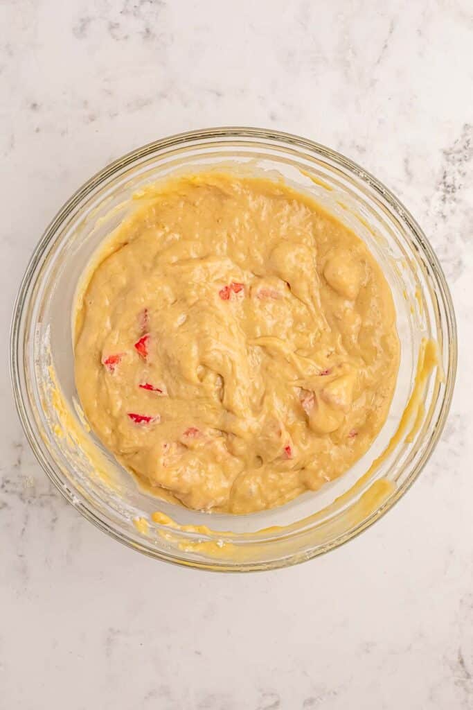 A large glass bowl of strawberry banana bread batter.